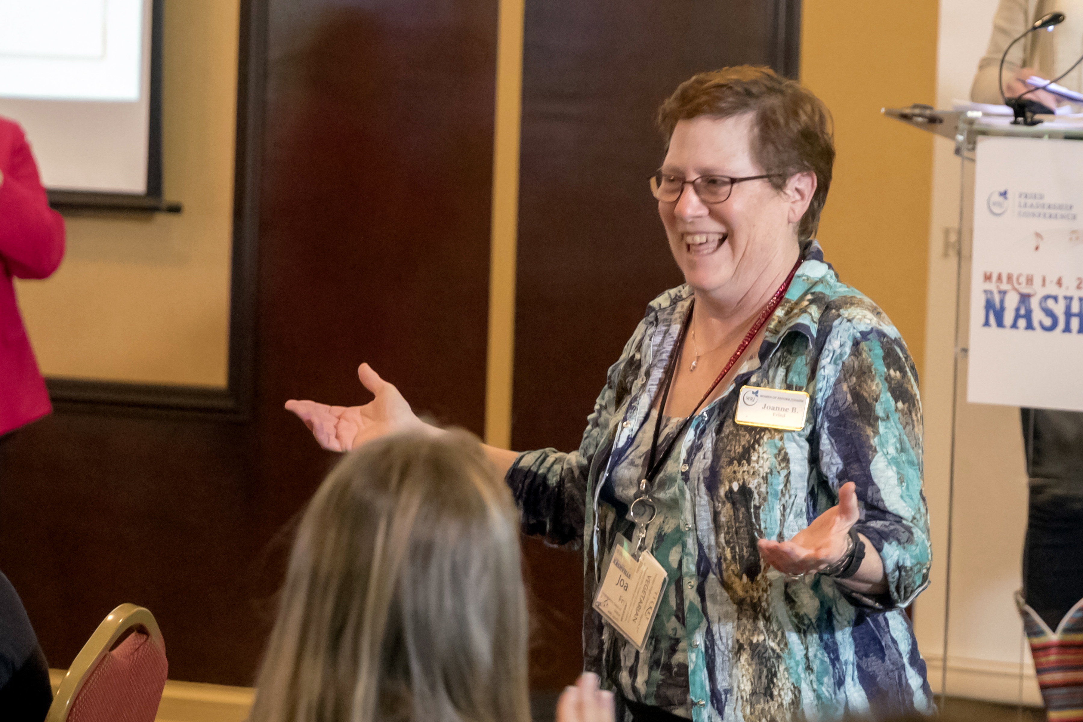 Animated woman speaking in front of a group