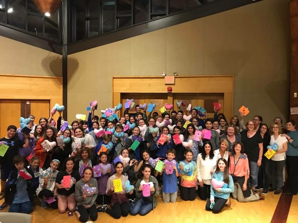 2020 Gold Or Ami Winner group of kids and adults holding heart shaped pillows