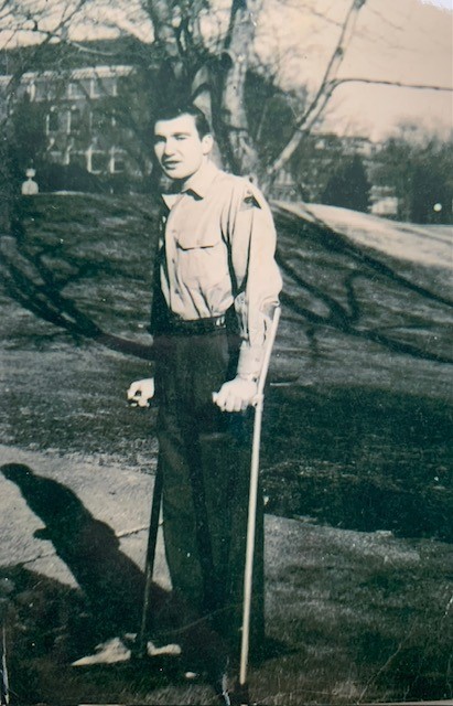 Black and white photo of young man on crutches