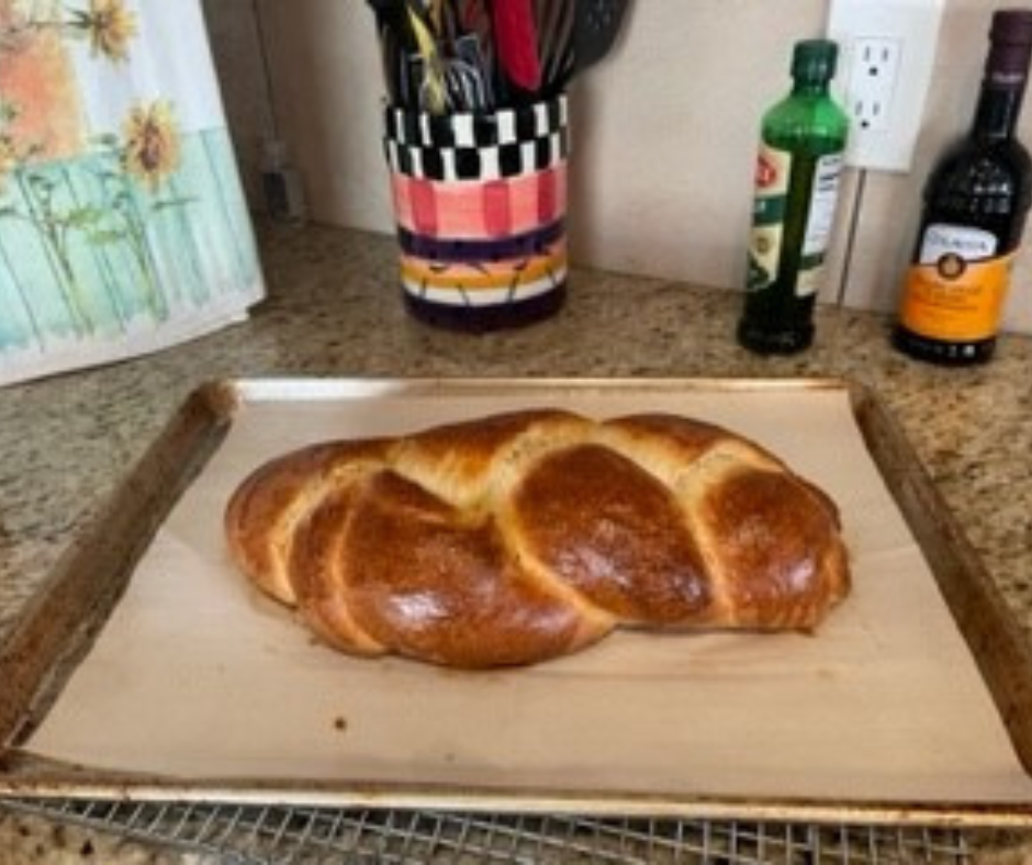 A challah on a baking tray on a kitchen counter. 
