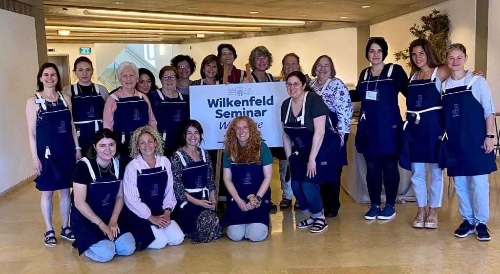 women wearing blue aprons at the Wilkenfeld International Women's Leadership Seminar Participant