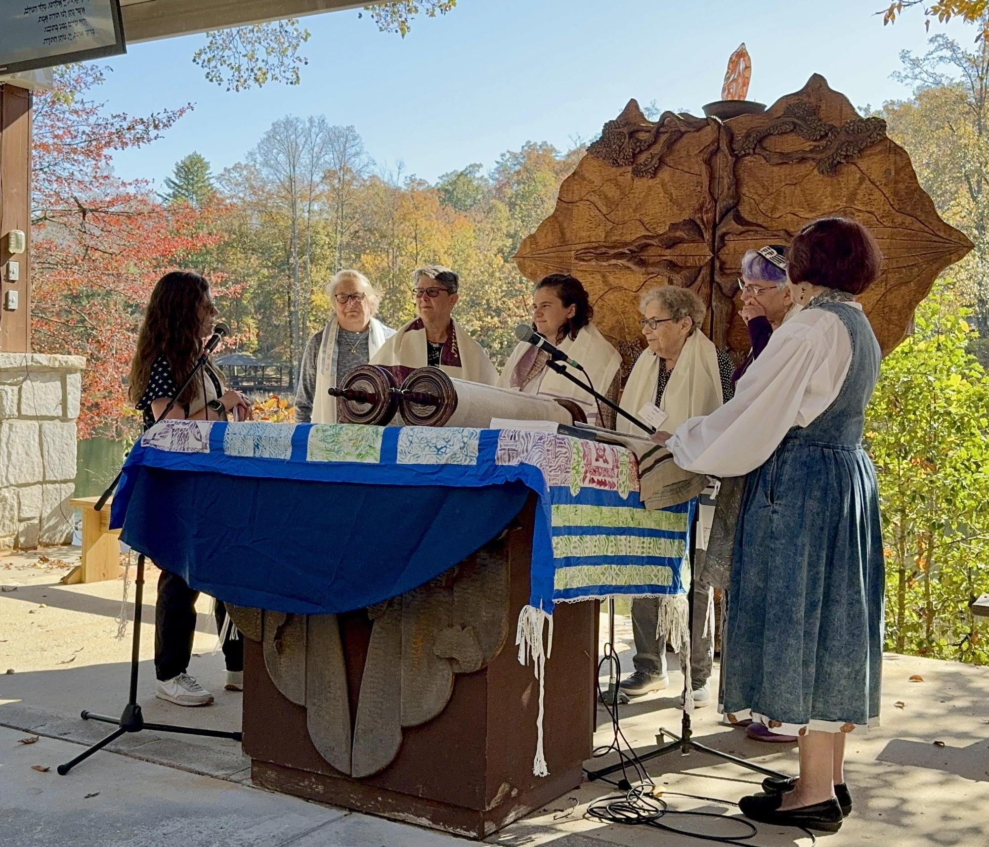 women standing behind a Torah alter receiving a prayer from rabbi