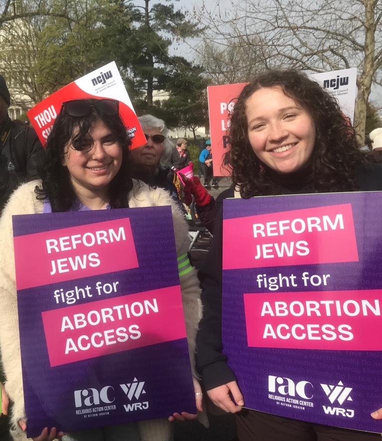 two women hold signs saying "reform jews for abortion justice"