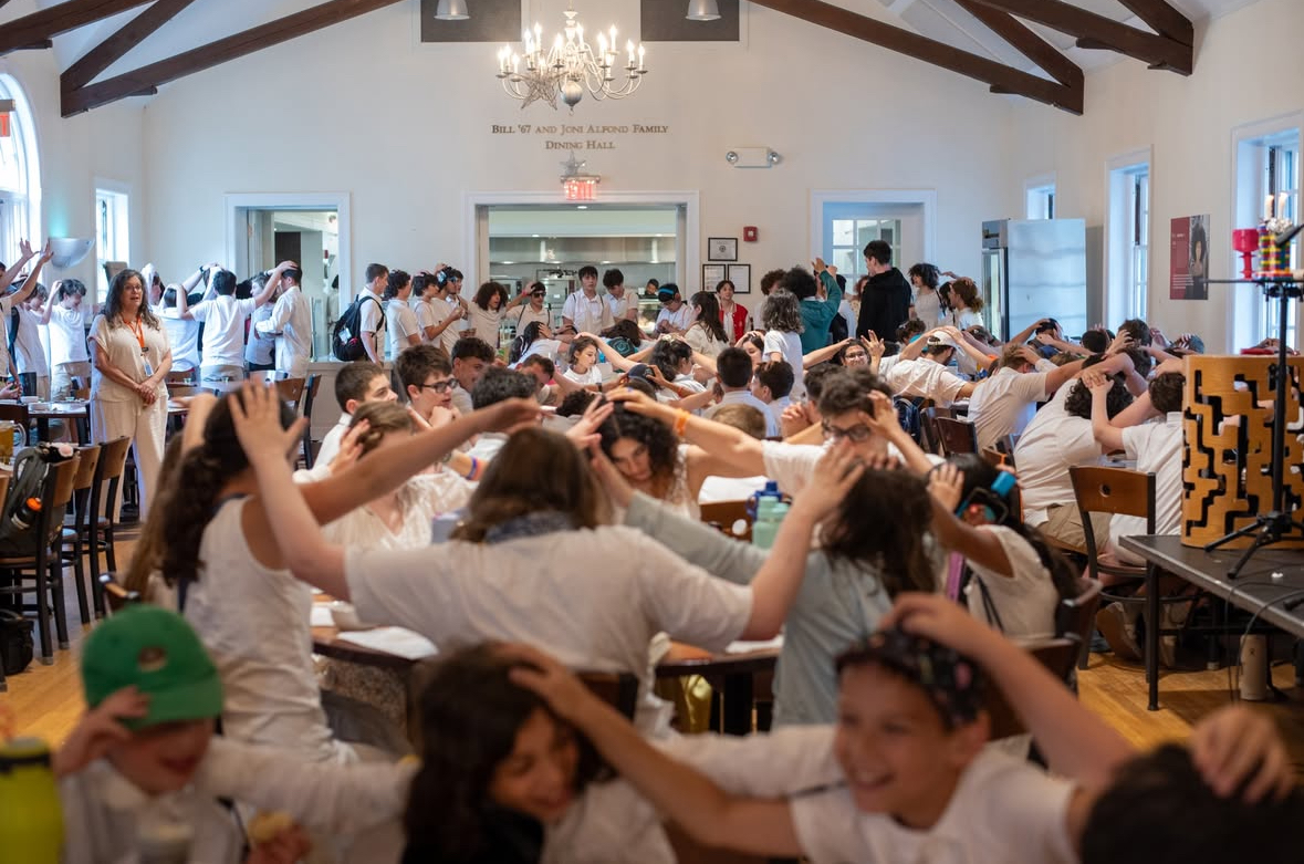 children at camp putting hands on each other's heads in prayer