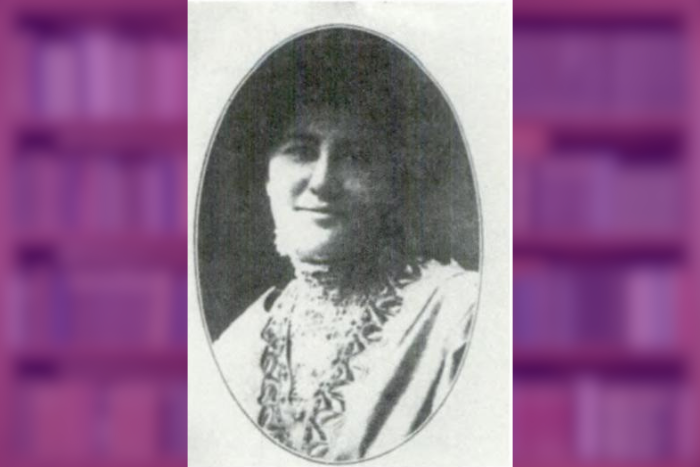 old photo of a woman smiling in front of a blurry image of books on shelves
