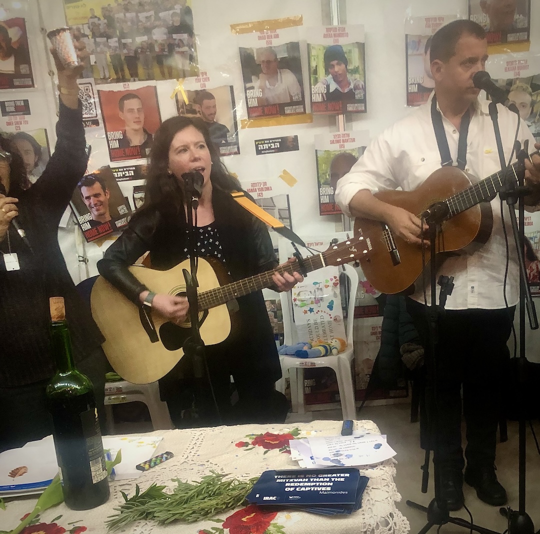 Liz singing with guitar, February 2024