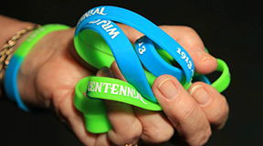Hand holding 100th celebration bracelets