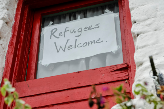 Refugees welcome written on a piece of paper in a window