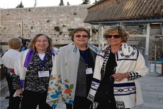 Three women standing in front of the Holy Wall 