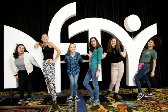 Teens standing by a NFTY sign