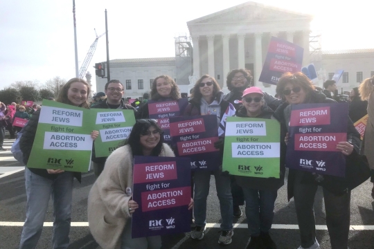 People standing together outside of the US Supreme Court holding signs that say "Reform Jews for Abortion Access"