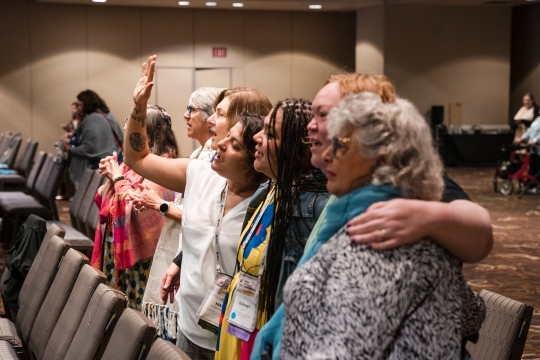 women standing with their arms around each other