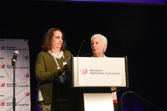 two women standing at podium with WRJ logo