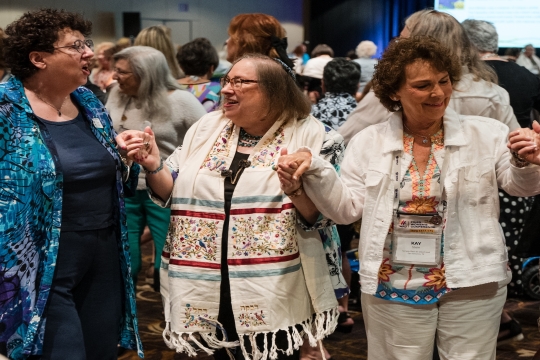 Three women holding hands in dance