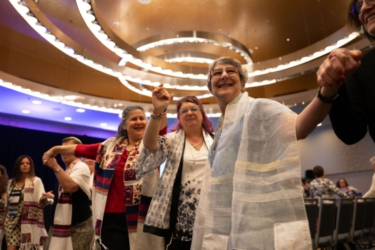 women holding hands smiling and dancing